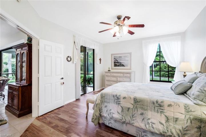 Primary bedroom with lanai access and wood look flooring.