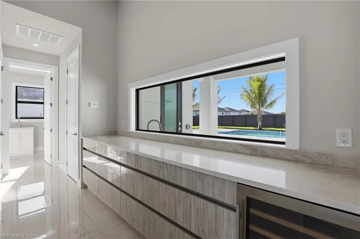 lots of drawers and wine fridge- large window looking at pool area