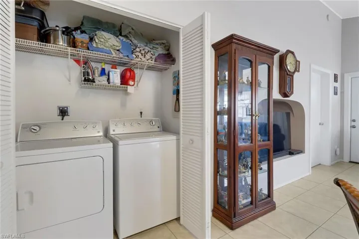 Washroom with light tile patterned floors and separate washer and dryer