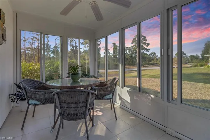 Sunroom with ceiling fan, baseboard heating, and a wealth of natural light