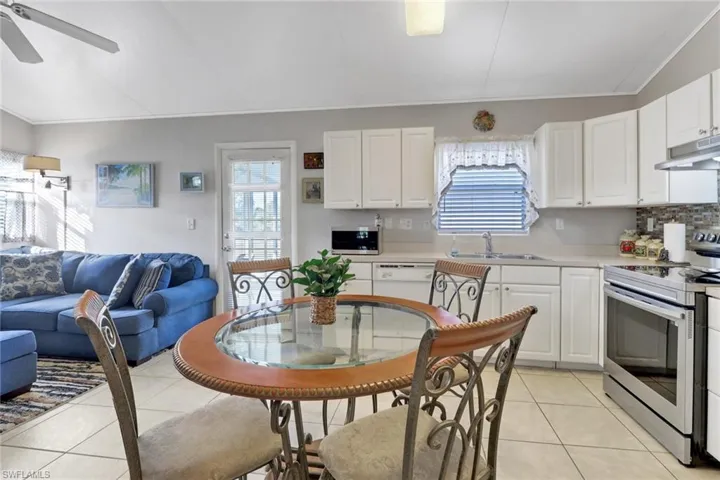 Kitchen with sink, stainless steel appliances, white cabinetry, and light tile patterned flooring