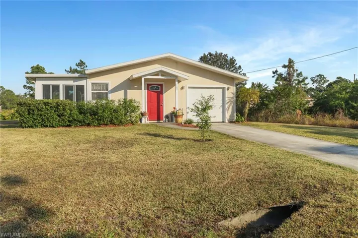 Single story home featuring a front lawn and a garage
