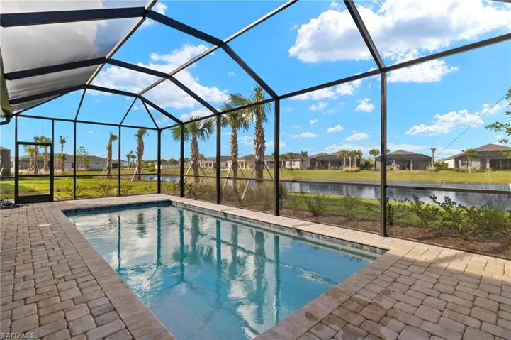 View of pool with a patio, a water view, and a lanai