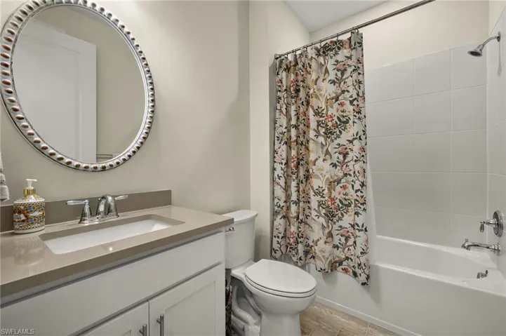2nd Full guest bathroom featuring wood-style tile floors, vanity, toilet, and shower / bathtub combination with curtain