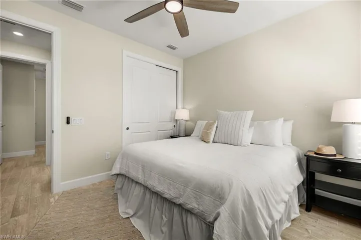 Bedroom with light wood-style tile flooring, a closet, and ceiling fan