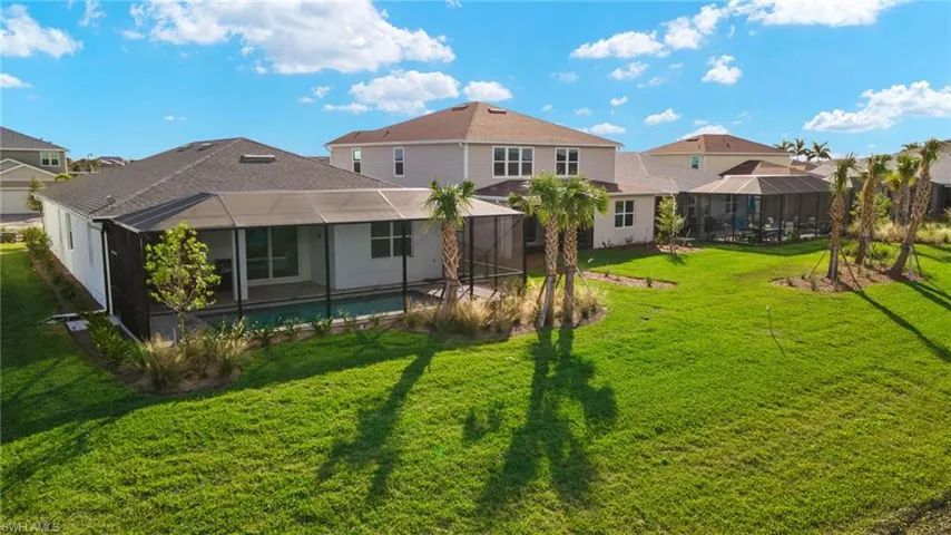 Rear view of property featuring a lawn, glass enclosure, and a swimming pool