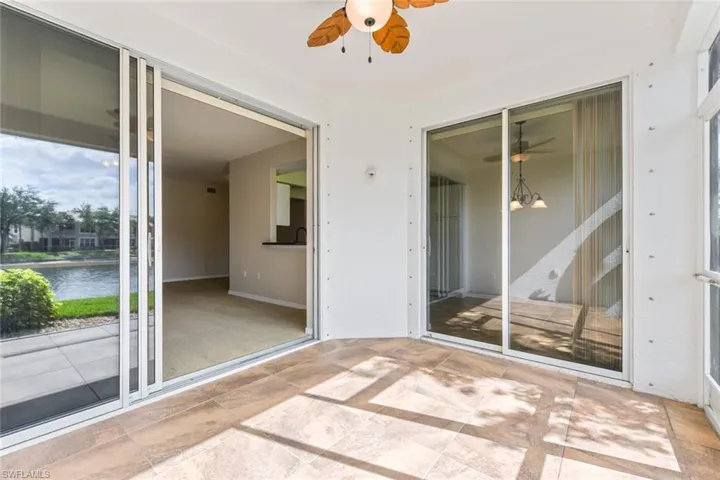Unfurnished sunroom featuring a water view and ceiling fan