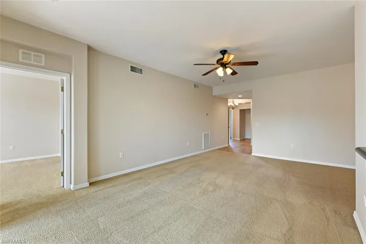 Spare room featuring a ceiling fan, carpet floors, and visible vents