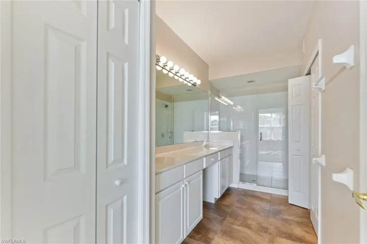 Bathroom featuring double vanity, a sink, and a stall shower