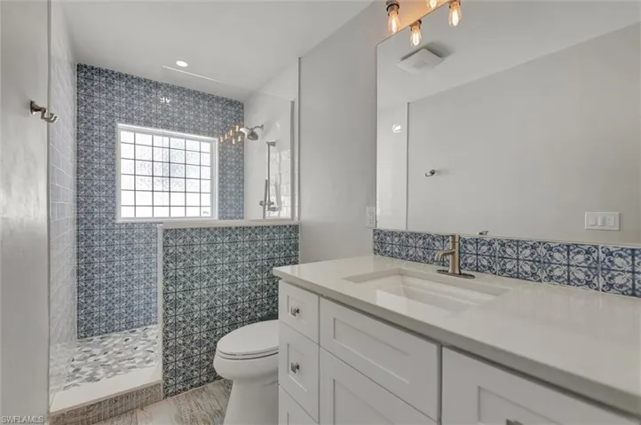 Full bath with a walk in shower, vanity, and toilet