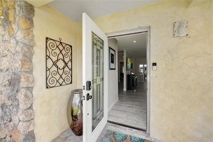 Doorway to property featuring stucco siding