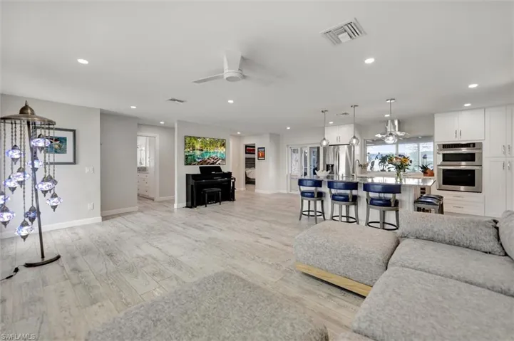 Living room featuring recessed lighting, light wood finished floors, visible vents, and ceiling fan