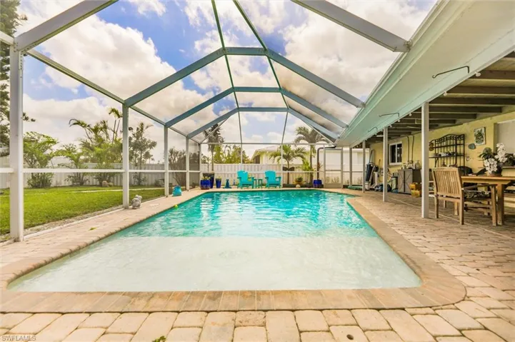 View of swimming pool featuring a patio area, a fenced backyard, glass enclosure, and a fenced in pool
