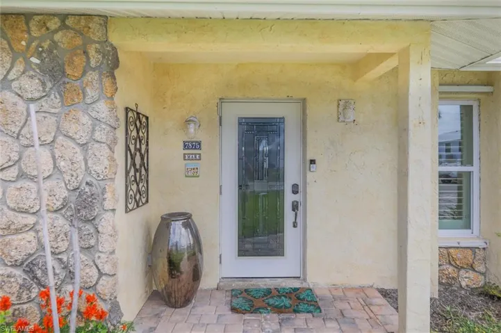 Entrance to property with stucco siding and stone siding