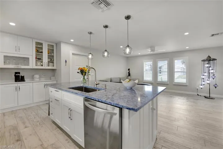 Kitchen with dishwasher, a sink, visible vents, and recessed lighting