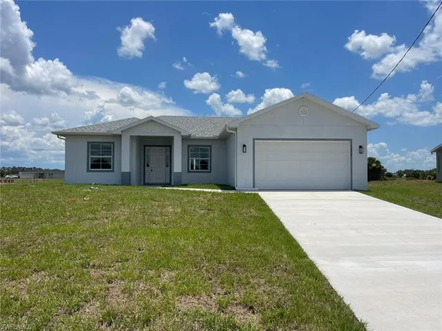 Ranch-style home with a garage and a front lawn