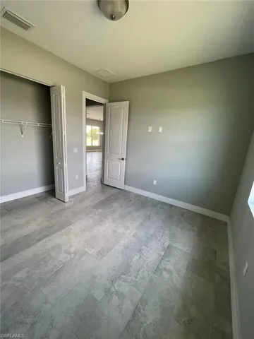 Unfurnished bedroom featuring tile flooring and a closet