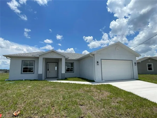 Ranch-style home with a front lawn and a garage