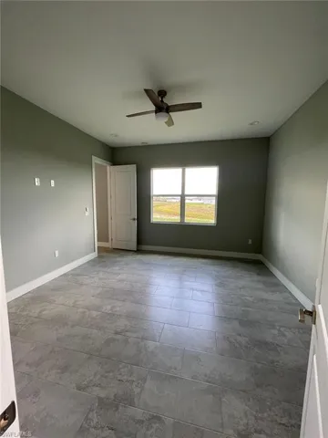 Unfurnished room featuring tile flooring and ceiling fan