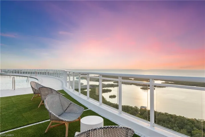 Balcony at dusk featuring a patio area and a water view