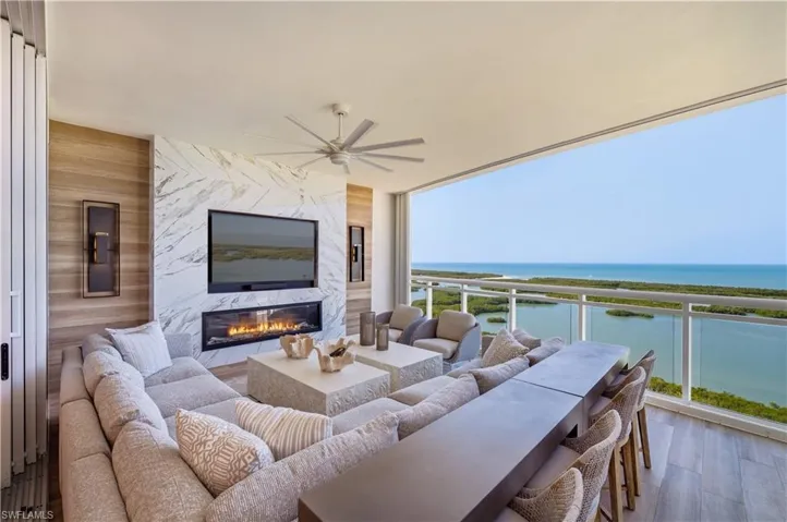 Balcony with a ceiling fan, an outdoor living / dining area, and a premium fireplace