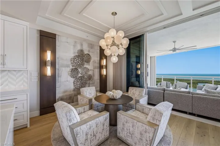 Dining area with light wood-type flooring, hanging lights, ceiling fan, and a water view