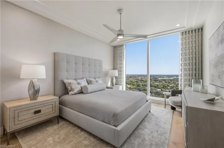 Bedroom with expansive windows, light wood-type flooring, ceiling fan, and recessed lighting