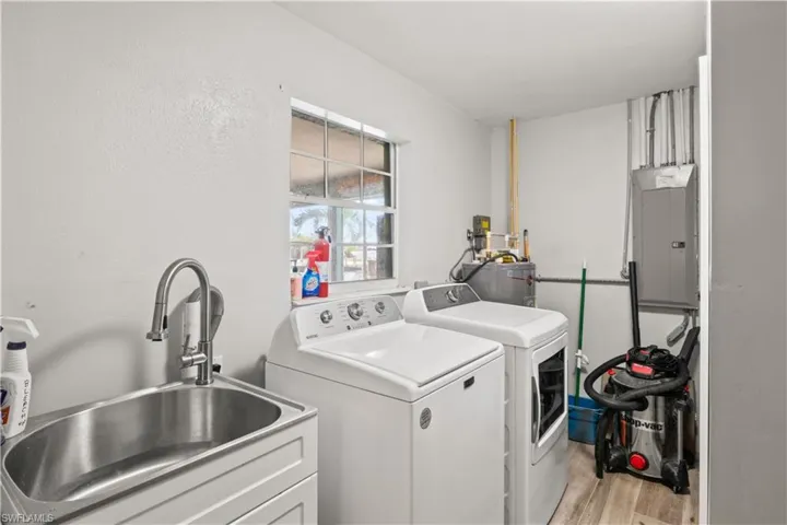 Separate laundry area with extra storage including a laundry tub.