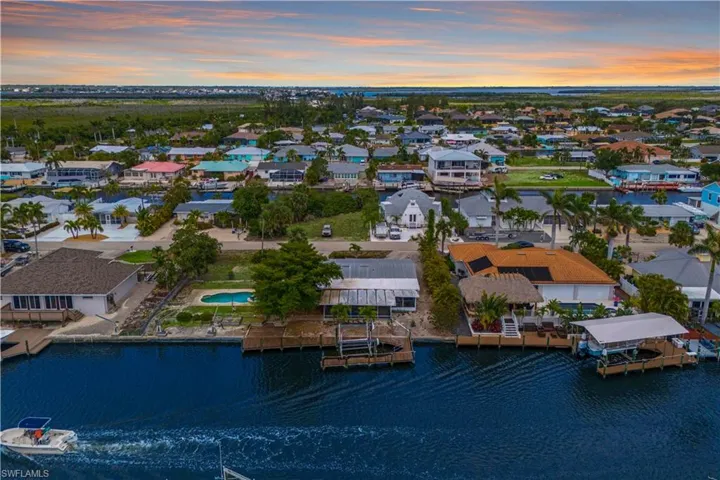 This aerial view offers a clear sense of the spacious lot, with the pool area and dock providing an ideal layout for waterfront living, giving you direct access to the water for boating and outdoor enjoyment.