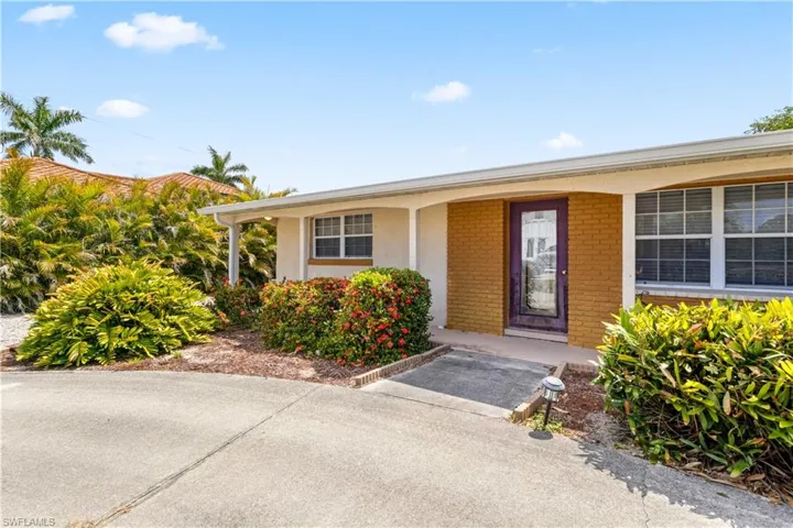 Mature tropical landscaping surrounds the home.