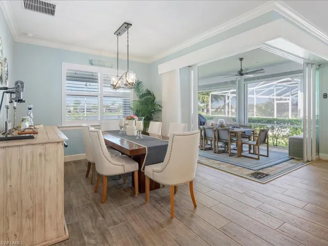 Dining space with notable chandelier, plantation shutters, and custom window treatments to the outdoor living space
