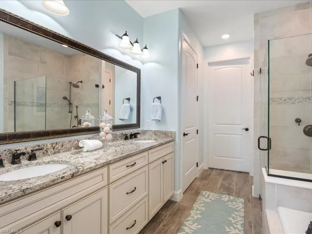 Primary Bathroom featuring dual vanity and a linen closet plus seperate water closet