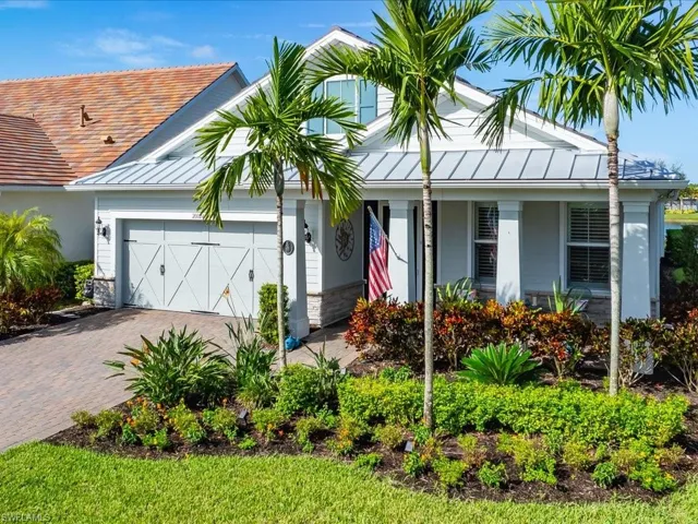View of front of home with a 2 car garage and custom landscaping