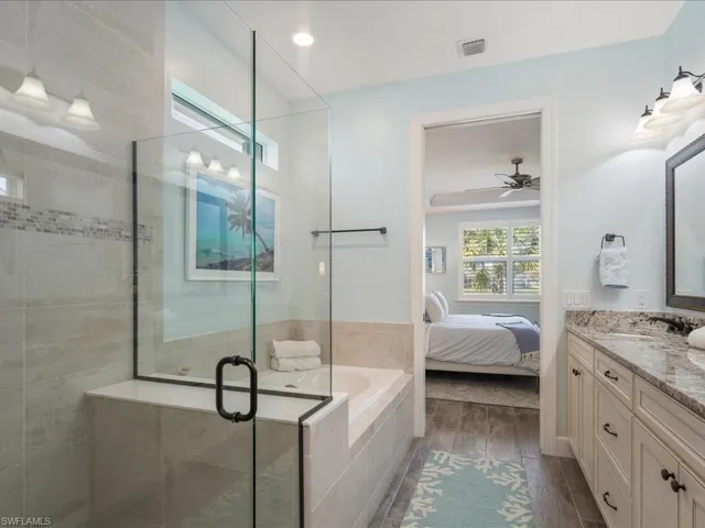 Primary Bathroom with vanity, plus walk in shower, ceiling fan, and access to the closet