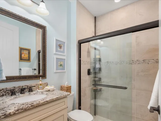 Guest Bathroom features toilet, vanity, and an enclosed shower