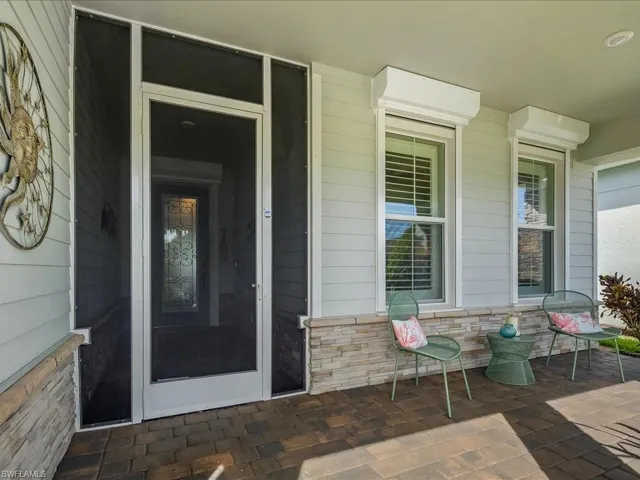 Property entrance featuring covered porch, electric storm shutters on front windows and screened entrance