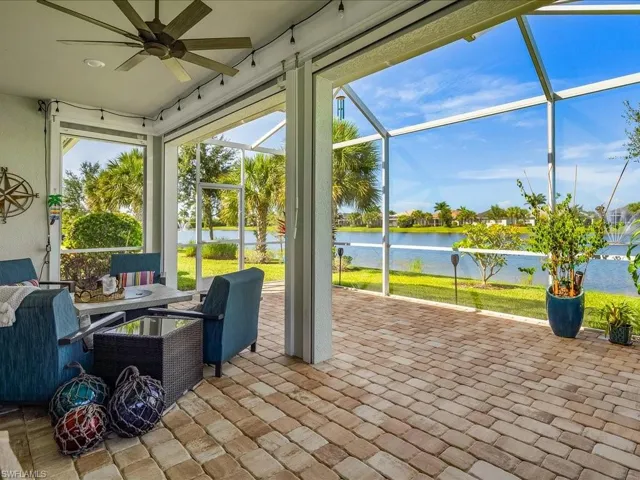 The screened enclosure features electric storm shutters and plenty of room for seating, dining, and barbecuing