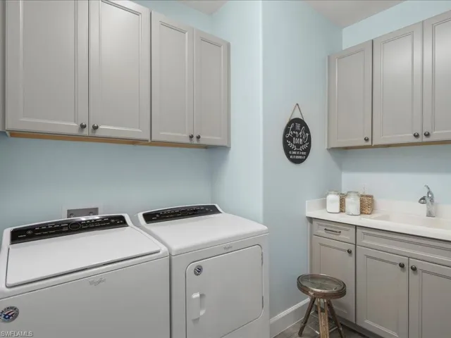 The utility room is spacious with bonus storage cabinets, independent washer and dryer, and sink