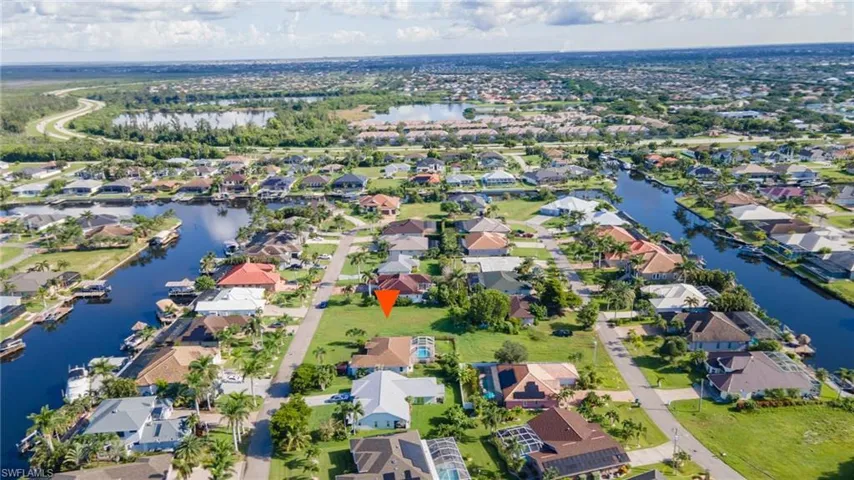Aerial view of property and surrounding area featuring a large body of water and nearby suburban area