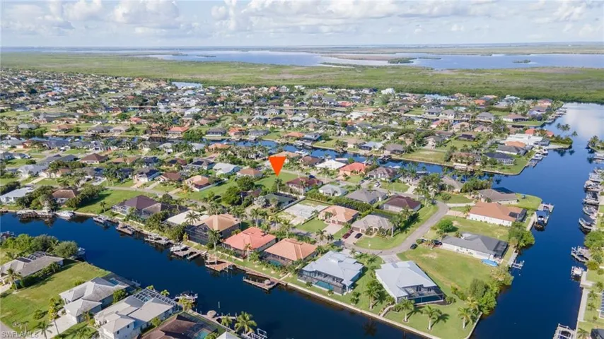 Aerial view of property's location with a nearby body of water and nearby suburban area
