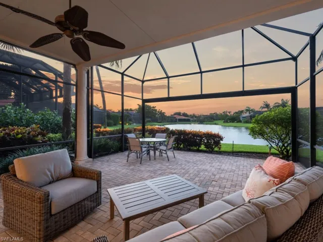 Lanai at dusk with a water view and picture window enclosure
