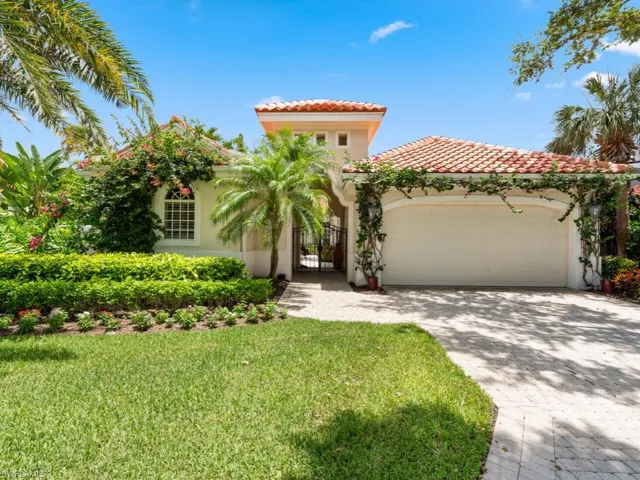 Mediterranean / spanish courtyard home featuring a 2 car garage and a front lawn