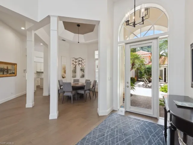 Foyer with volume ceiling, chandelier and ornate columns