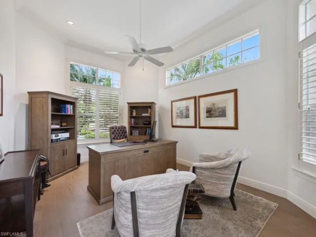 Office/den with a high ceiling, crown molding, ceiling fan, and hardwood / wood-style floors