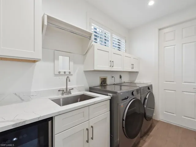 Laundry room with washer, dryer, sink and wine cooler