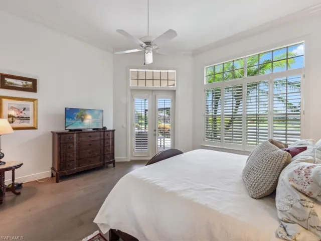 Primary bedroom featuring ceiling fan, french doors, wood-type flooring, access to outside, crown molding and lake view