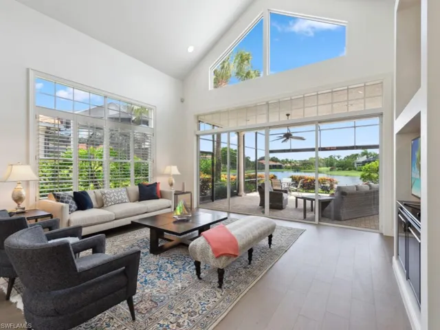 Living room featuring high vaulted ceiling, ceiling fan, and a water view