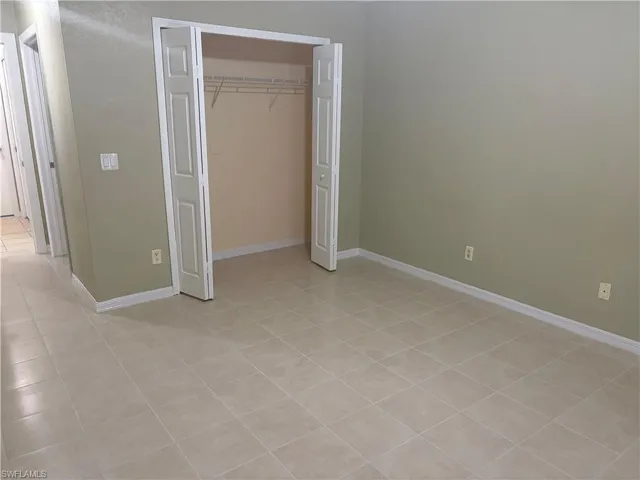 Neutral-toned room featuring a closet with bi-fold doors and wire shelving