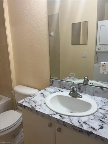 Bathroom vanity with a white oval sink, chrome faucet, and marble-look countertop