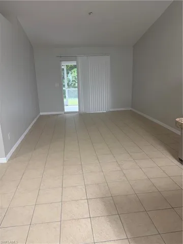 Spacious interior with vaulted ceilings, neutral wall tones, and large format tiled flooring